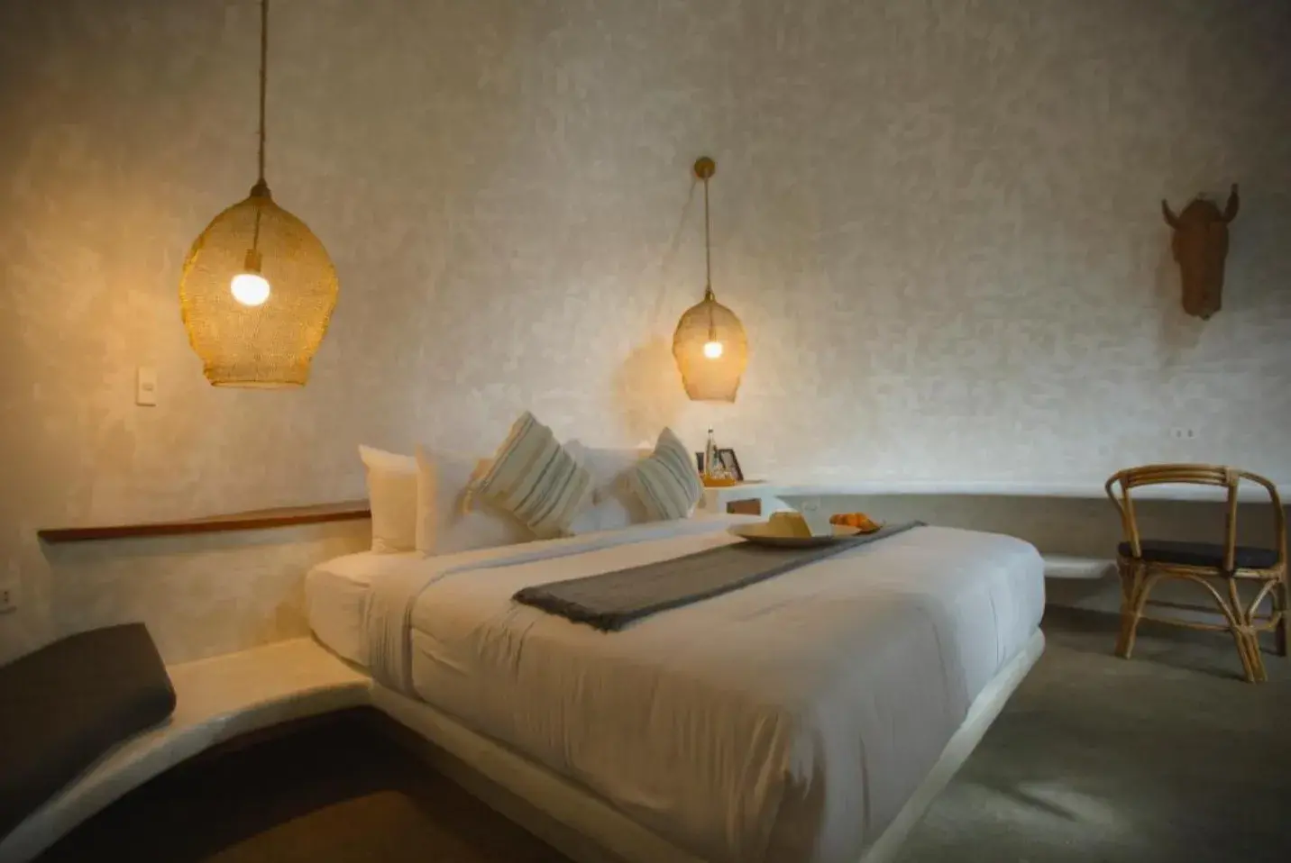 Suite Deluxe avec un lit en linge blanc, des suspensions en fibre et une chaise en rotin