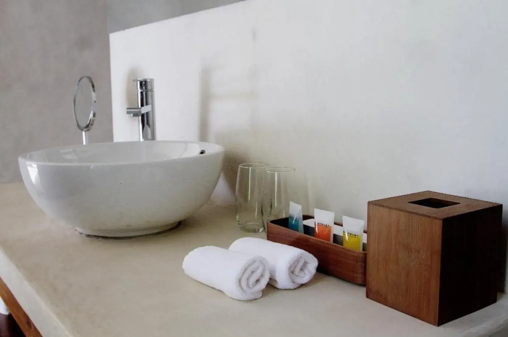 Vasque blanche de la Suite Deluxe avec serviettes et produits de toilette